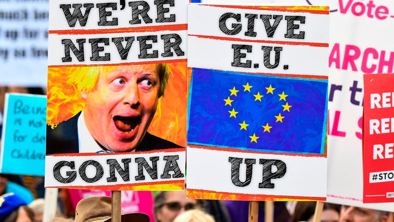 Demonstrators hold placards and EU and Union flags as they take part in a march by the People's Vote organisation