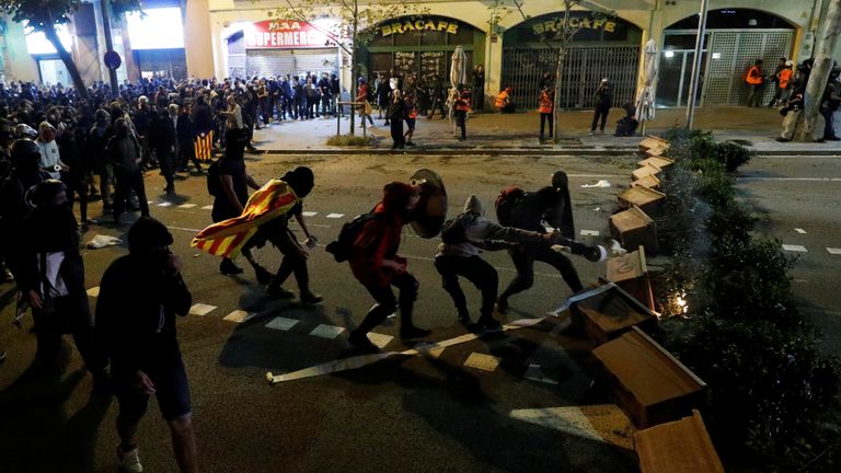 Protesters are seen behind a barricade as they clash with police