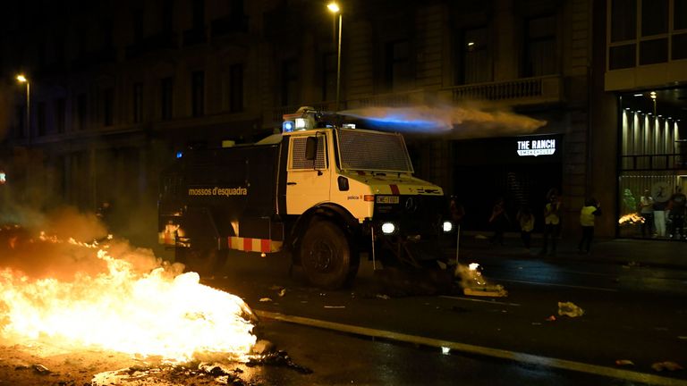 Catalan regional police fire water cannons to extinguish burning barricades 