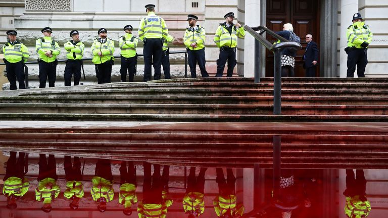 Police stands in front of the Treasury building during an Extinction Rebellion protest