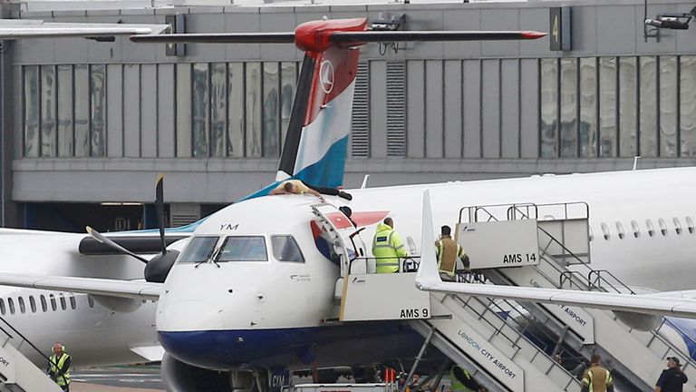 A protester, who Extinction Rebellion says is former Paralympic athlete James Brown, lies on top of a British Airways plane at London City Airport