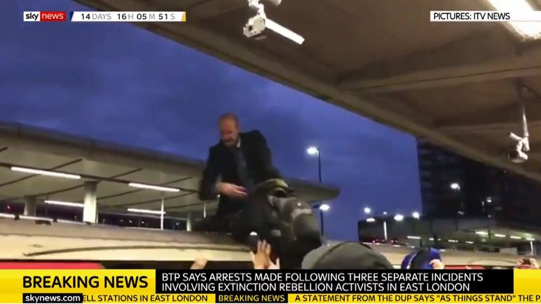 An Extinction Rebellion protester is pulled off a train in Canning Town. Pic: ITVNEWS