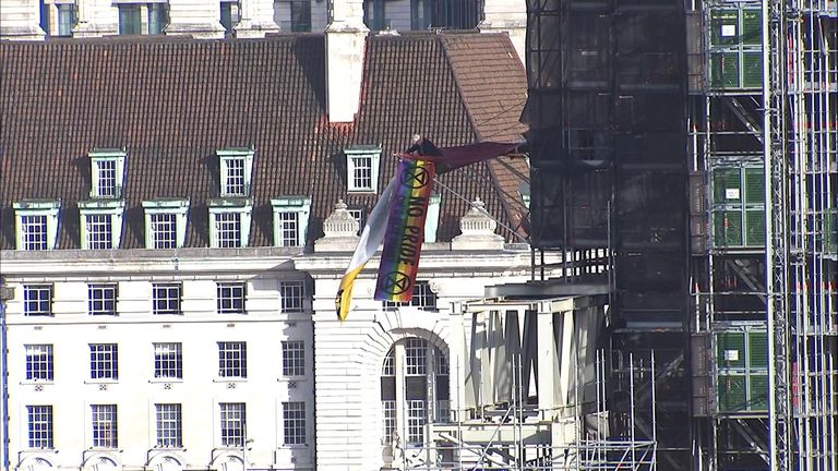 An extinction rebellion protester has unveiled a flag on a crane on Big Ben.