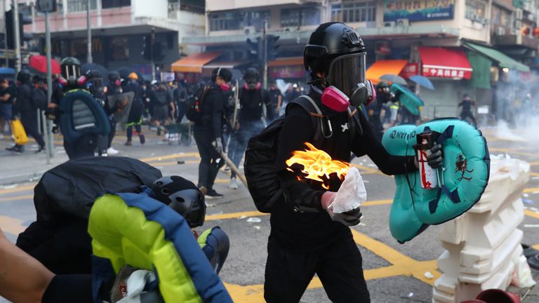 An anti-government protester carries a molotov cocktail during a protest in Sham Shui Po district
