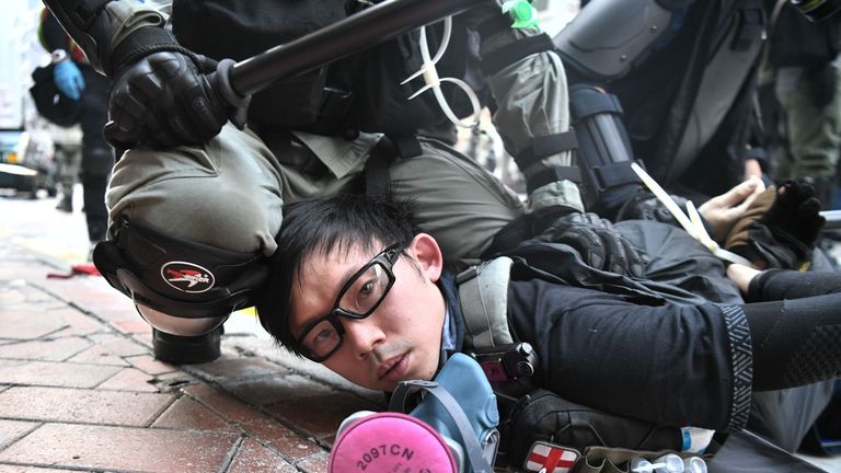 A protester is detained by police as violent demonstrations take place in the streets of Hong Kong on October 1, 2019
