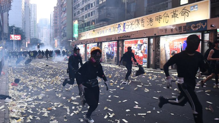 Protesters run from police during clashes in the Wanchai district in Hong Kong on October 1, 2019