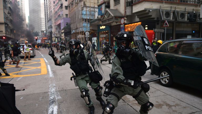 Hong Kong police chase after protesters in the street during demonstrations in the Wanchai district in Hong Kong on October 1, 2019