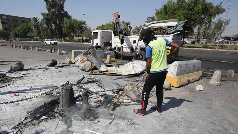 Workers sweep up bullets and debris on Saturday morning