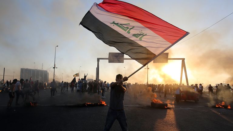 An Iraqi protester waves the national flag during protests on Saturday