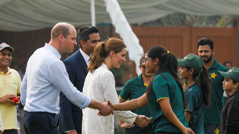 Prince William and Catherine, Duchess of Cambridge, shake hands with children participants of the British Council's DOSTI (friendship) program at the National Cricket Academy in Lahore, Pakistan on Thursday