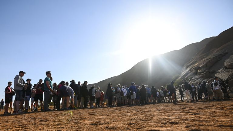 Tourists line up to climb Uluru