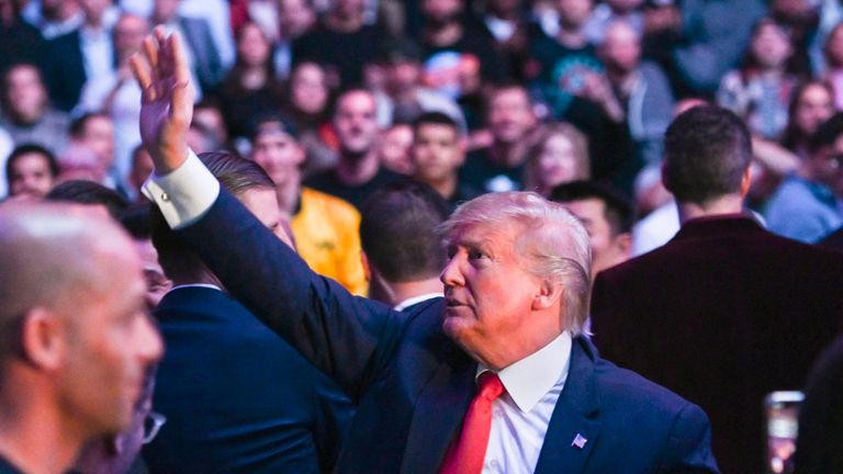 US President Donald Trump waves to the crowd as he attends a UFC match
