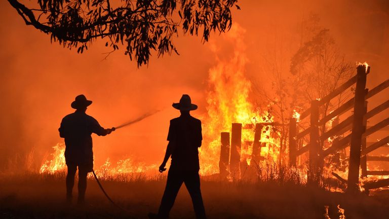 Residents defend a property from a bushfire at Hillsville near Taree, 350km north of Sydney on November 12, 2019