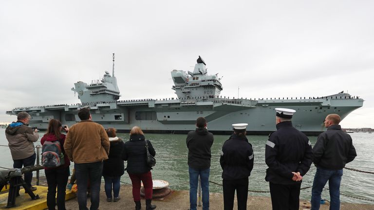 Family and friends wait on the jetty as HMS Prince of Wales arrives at Portsmouth Naval Base