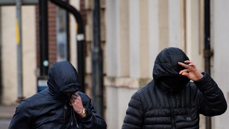 George Powell and Layton Davies cover their faces outside court