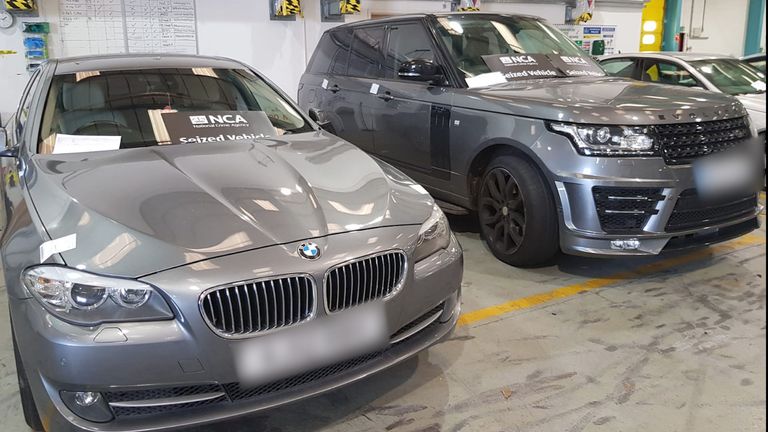 A BMW 5 series and a Range Rover Vogue after they were both recovered by officers