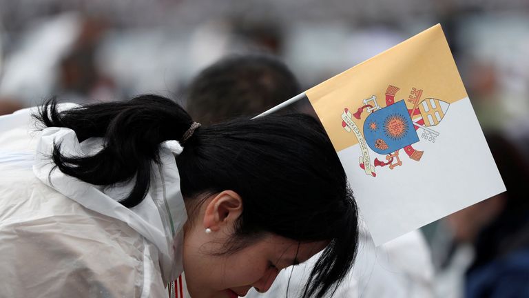 A wellwisher with a flag bearing the coat of arms of Pope Francis waits for his arrival for a Holy Mass in Nagasaki 