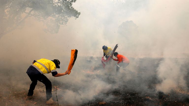 Residents try to knock down spot fires, from a bushfire, heading towards a house on a property at Koorainghat, near Taree in the Mid North Coast region of NSW, Australia, November 12, 2019