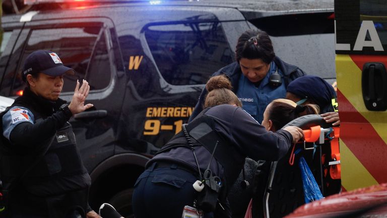 A woman receives medical assistance on the scene where active shooting is happening in Jersey City on December 10, 2019. - One officer was shot when two gunmen with a long rifle opened fire in Jersey City, New Jersey, on the afternoon of December 10, 2019 , according to two officials. Two suspects were barricaded in a convenience store, the officials said. One officer was being taken to a nearby hospital. (Photo by Kena Betancur / AFP) (Photo by KENA BETANCUR/Afp/AFP via Getty Images)