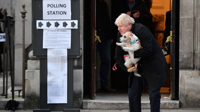 Britain&#39;s Prime Minister Boris Johnson poses with his dog Dilyn as he leaves from a Polling Station, after casting his ballot paper and voting, in central London on December 12, 2019, as Britain holds a general election. (Photo by DANIEL LEAL-OLIVAS / AFP) (Photo by DANIEL LEAL-OLIVAS/AFP via Getty Images)