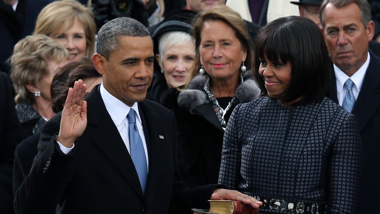 WASHINGTON, DC - JANUARY 21:  U.S. President Barack Obama is sworn in during the public ceremony as First lady Michelle Obama looks on during the presidential inauguration on the West Front of the U.S. Capitol January 21, 2013 in Washington, DC.   Barack Obama was re-elected for a second term as President of the United States.  (Photo by Alex Wong/Getty Images)