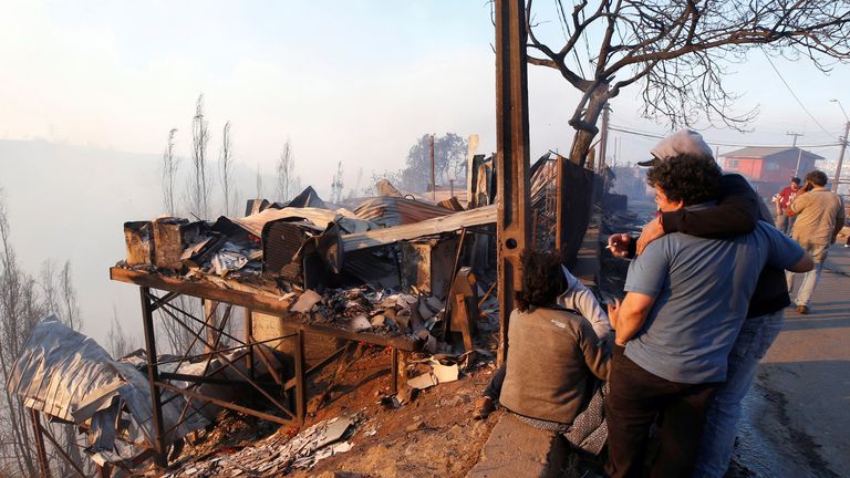 People react next to the debris of their house following the spread of wildfires in Valparaiso, Chile, December 24, 2019. REUTERS/Rodrigo Garrido