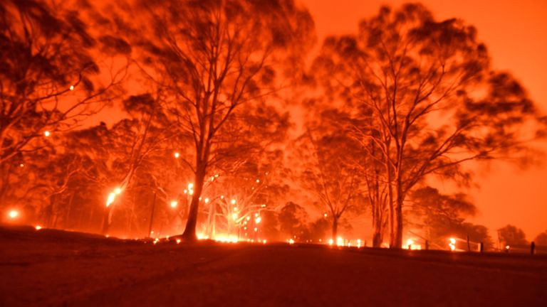 The afternoon sky glows orange from bushfires in the area around the town of Nowra in the Australian state of New South Wales on December 31, 2019. - Thousands of holidaymakers and locals were forced to flee to beaches in fire-ravaged southeast Australia on December 31, as blazes ripped through popular tourist areas leaving no escape by land. (Photo by Saeed KHAN / AFP) (Photo by SAEED KHAN/AFP via Getty Images)