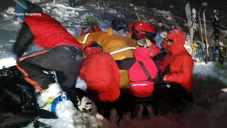 Dağ kurtarma, onu karda gömülü bulduktan sonra ısınmasına yardımcı olmak için adamın üzerine bir örtü koydu.  Resim: Bergrettung