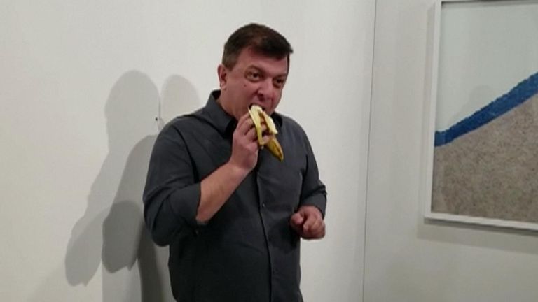 Performance artist David Datuna ate Maurizio Cattelan&#39;s piece of a banana taped to the wall in front of a curious crowd
