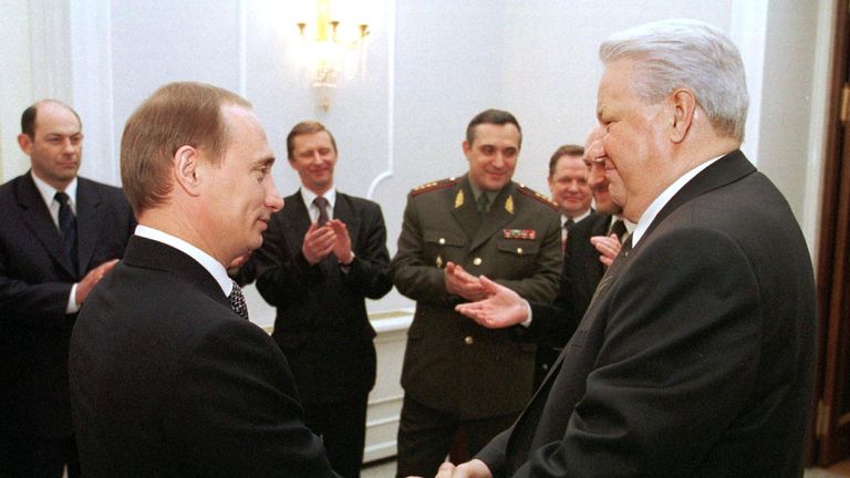 MOSCOW, RUSSIA - DECEMBER 31: Russian President Boris Yeltsin (R) shakes hands with Prime Minister Vladimir Putin (L) during a farewell ceremony in Kremlin in Moscow, as members of the Presidential administration and the government look on and applaud 31 December 1999. Boris Yeltsin earlier today announced that he was resigning immediately and that Vladimir Putin, according to the Russian Constitution, would run the country as acting President until presidential elections in March 2000. (Photo c
