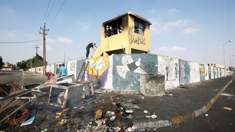An Iraqi demonstrator climbs to Iraqi security forces check room during ongoing anti-government protests in Nassiriya, Iraq December 4, 2019. Picture taken December 4, 2019. REUTERS/Alaa al-Marjani