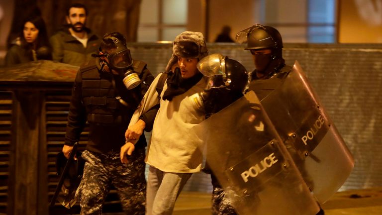 Riot police detain an anti-government demonstrator during clashes in the capital Beirut
