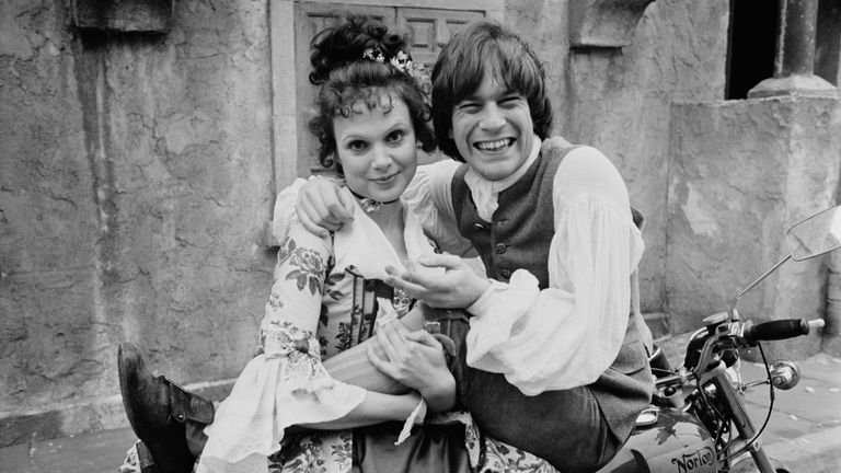 British actors Madeline Smith as 'Sophia' and Nicky Henson as 'Tom Jones' on a motorcycle on the set of British comedy film 'The Bawdy Adventures of Tom Jones', UK, 2nd April 1975