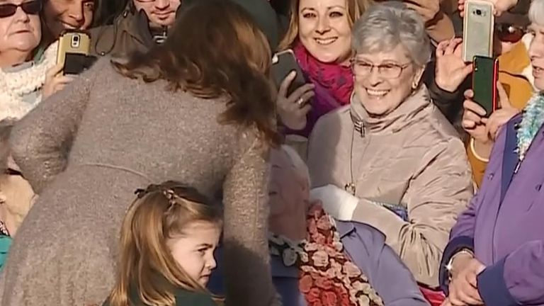 Princess Charlotte looks along a line of public waiting for a glimpse of royalty