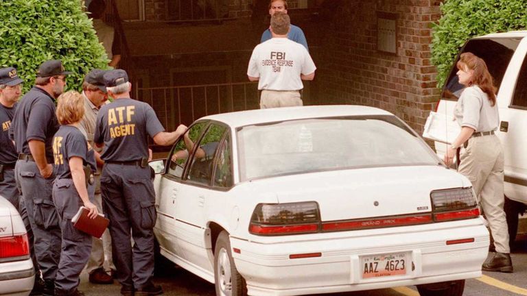 US Federal agents gather 31 July outside the home of Richard Jewell, the security guard who was working at Centennial Park at the time of the 27 July pipe bomb explosion. Federal authorities reportedly searched the apartment for evidence that might link Jewell to the bombing