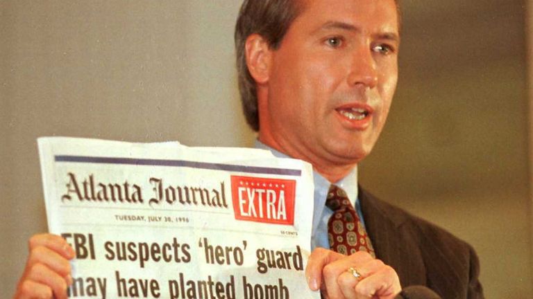 Richard Jewell Attorney Lin Wood holds a copy of the Atlanta Journal during a press conference 28 October 1996. Wood said Jewell plans to file suit against several media sources for defamation of character