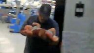 Lazaro Ponce carries baby Paul from the El Paso Walmart. Pic: Lem Arrendondo 