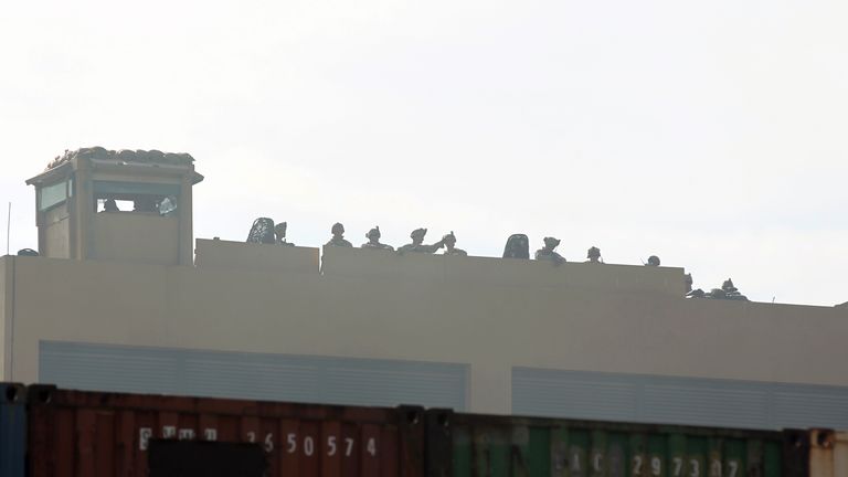 US forces stand guard at the roof of the US embassy in the Iraqi capital Baghdad on January 1, 2020 during a demonstration by supporters and members of the Hashed al-Shaabi paramilitary force. - Thousands of Iraqi supporters of the largely Iranian-trained Hashed al-Shaabi paramilitary force had gathered at the embassy, outraged by US strikes that killed 25 Hashed fighters over the weekend. They marched unimpeded through the checkpoints of the usually high-security Green Zone to the embassy gates, where they broke through a reception area, chanting "Death to America" and scribbling pro-Iran graffiti on the walls. (Photo by AHMAD AL-RUBAYE / AFP) (Photo by AHMAD AL-RUBAYE/AFP via Getty Images)