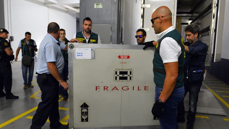 Spanish Civil Guards and museum employees push a box containing Picasso's painting "Head of a Young Woman" at the Reina Sofia museum in Madrid after being transferred from the French island of Corsica, on August 11, 2015. The Picasso worth more than 25 million euros and owned by the Spanish banker Jaime Botin, was transferred to Reina Sofia museum today after it was seized from a yacht on July 31 by French customs agents who accused the painting's owner of trying to illegally export it to Switzerland. AFP PHOTO / GERARD JULIEN        (Photo credit should read GERARD JULIEN/AFP via Getty Images)