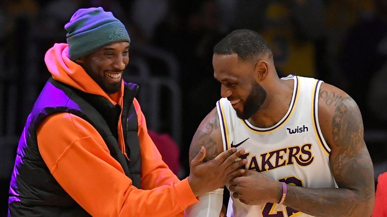 Kobe Bryant and LeBron James share a joke courtside during a Lakers game
