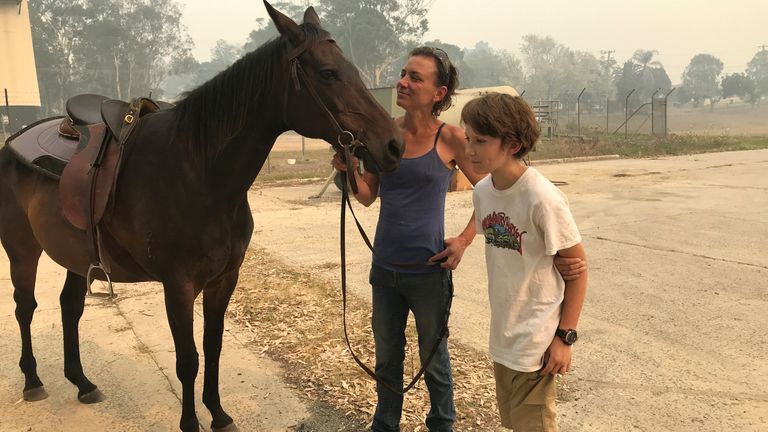 Bec Winter stands next to her son, Riley, and her horse Charmer, who she rode to safety through bushfires on New Year&#39;s Eve