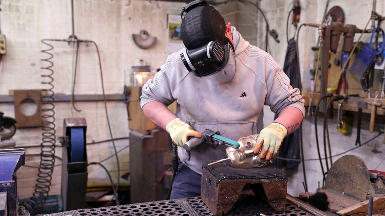 Fettler Piotr Lichon works on a mask during the casting of the British Academy of Film and Television Awards (BAFTA) masks at a foundry in West Drayton, west London, ahead of the ceremony on February 2