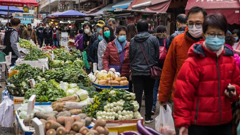 Shoppers in Hong Kong wear face masks as the government shut down parts of the border with China