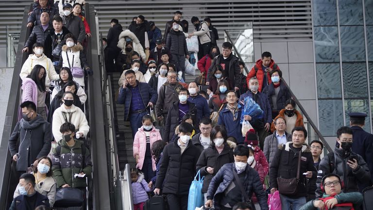 Passengers at Shanghai railway station wear facemasks as they travel home for the Lunar New Year