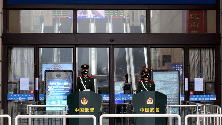 Chinese paramilitary officers wearing masks stand guard outside a shut Hankou Railway Station in Wuhan