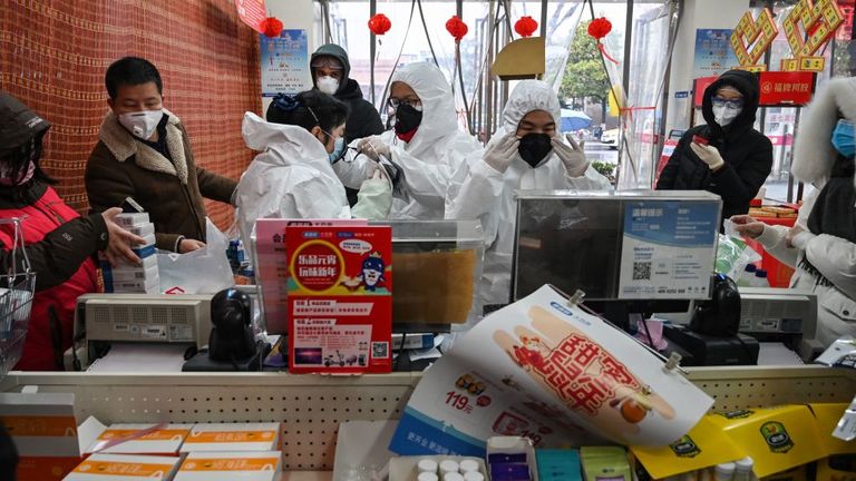Pharmacy workers wearing protective clothes and masks serve customers in Wuhan 