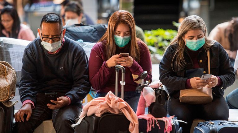 Passengers wear face masks to protect against the spread of the Coronavirus as they arrive on a flight from Asia at Los Angeles International Airport, California, on January 29, 2020. - A new virus that has killed more than one hundred people, infected thousands and has already reached the US could mutate and spread, China warned, as authorities urged people to steer clear of Wuhan, the city at the heart of the outbreak. (Photo by Mark RALSTON / AFP) (Photo by MARK RALSTON/AFP via Getty Images)
