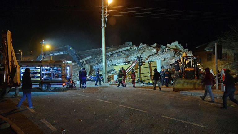 Turkish officials and police work at the scene of a collapsed building following a 6.8 magnitude earthquake in Elazig