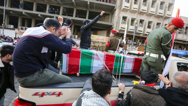 Iraqis mourn over a coffin during the funeral procession which drew thousands of supporters to the streets