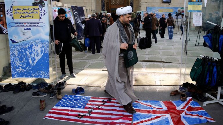 An Iranian cleric walking over British and US flags Pic: Shutterstock